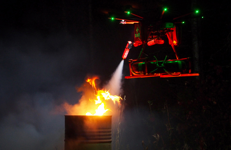 Flying robot extinguishing small fire.