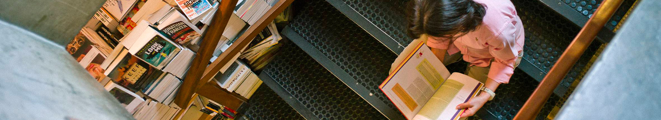 Person reading book sitting on a staircase